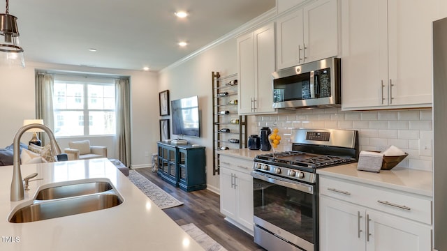 219 Carova Bnd, Apex, NC 27539 - kitchen featuring appliances with stainless steel finishes, a sink, light countertops, dark wood-type flooring, and backsplash