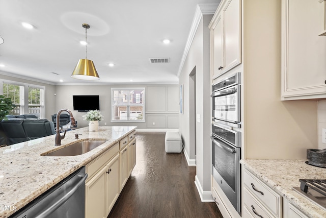 1313 Littlehills Dr, Apex, NC 27523 - kitchen with open floor plan, appliances with stainless steel finishes, ornamental molding, dark wood-style flooring, and light stone counters