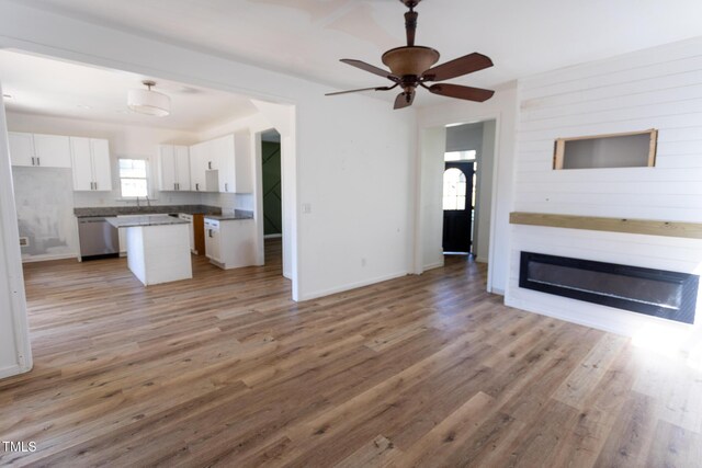 328 Mccarthy Dr, Clayton, NC 27527 - unfurnished living room with light wood-type flooring, baseboards, ceiling fan, and a fireplace