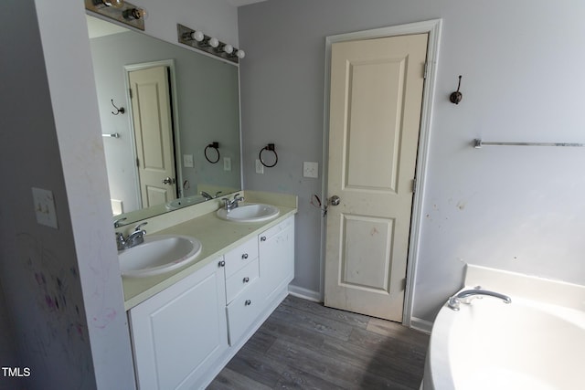 328 Mccarthy Dr, Clayton, NC 27527 - bathroom with double vanity, wood finished floors, a bathtub, and baseboards