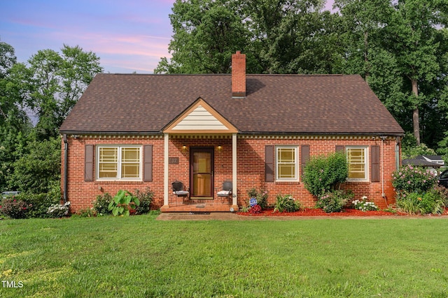 132 Lord Ashley Rd, Raleigh, NC 27610 - view of front of property with a chimney, brick siding, a yard, and roof with shingles