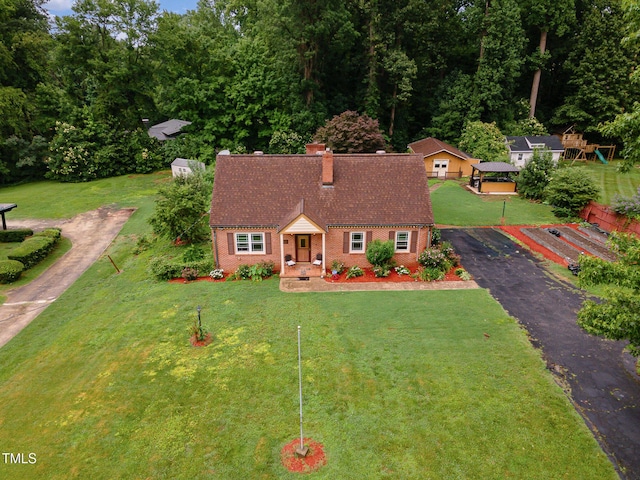 132 Lord Ashley Rd, Raleigh, NC 27610 - view of front of home with brick siding, a chimney, driveway, and a front yard