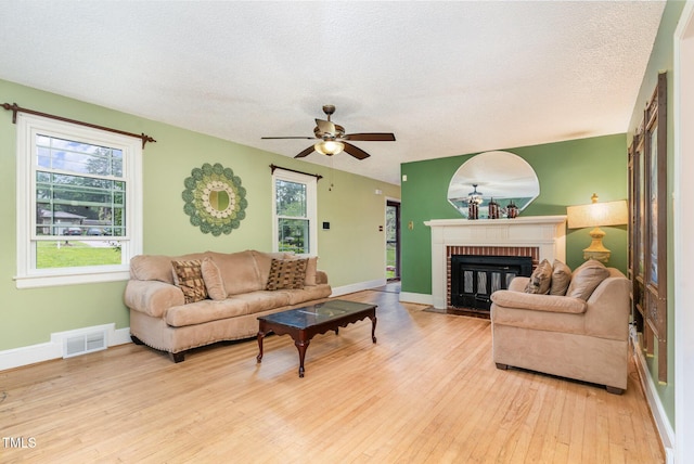 132 Lord Ashley Rd, Raleigh, NC 27610 - living room featuring a fireplace, hardwood / wood-style floors, ceiling fan, and a textured ceiling