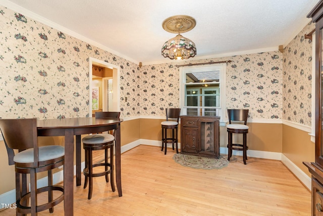 132 Lord Ashley Rd, Raleigh, NC 27610 - dining room with crown molding, wood finished floors, and wallpapered walls