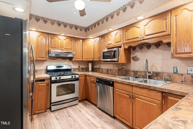 132 Lord Ashley Rd, Raleigh, NC 27610 - kitchen featuring stainless steel appliances, under cabinet range hood, a ceiling fan, light wood-type flooring, and backsplash