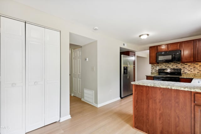 104 Benedict Ln, Raleigh, NC 27614 - kitchen featuring black appliances, decorative backsplash, light wood finished floors, baseboards, and light stone countertops