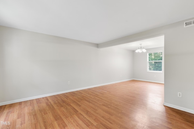 104 Benedict Ln, Raleigh, NC 27614 - spare room featuring a chandelier, light wood-style floors, and baseboards