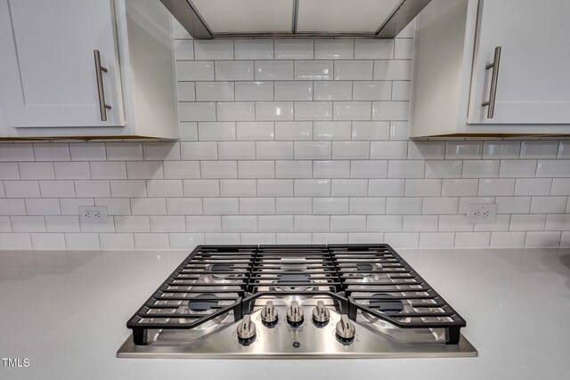 321 Calvander Ln, Apex, NC 27539 - kitchen view of stainless steel gas cooktop, light countertops, backsplash, and white cabinets