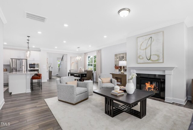 321 Calvander Ln, Apex, NC 27539 - living room featuring crown molding, dark wood finished floors, recessed lighting, a fireplace with flush hearth, and baseboards