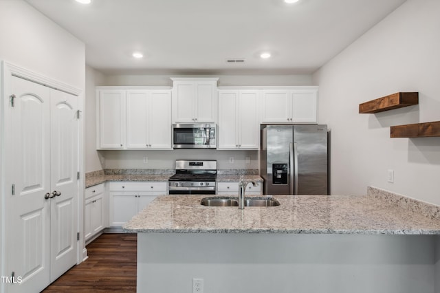 933 Weatherby Ln, Creedmoor, NC 27522 - kitchen with appliances with stainless steel finishes, light stone counters, a peninsula, white cabinetry, and recessed lighting