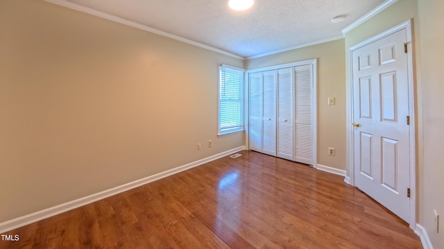 1446 Cimarron Pkwy Unit 64, Wake Forest, NC 27587 - unfurnished bedroom with wood finished floors, a closet, ornamental molding, baseboards, and a textured ceiling