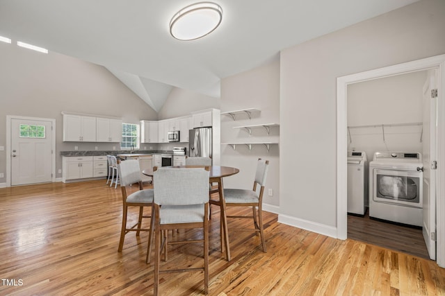 225 E End Ave, Durham, NC 27703 - dining space featuring washing machine and clothes dryer, light wood-style flooring, high vaulted ceiling, and baseboards