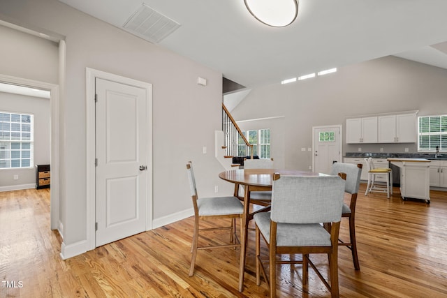 225 E End Ave, Durham, NC 27703 - dining space featuring stairs, light wood-type flooring, baseboards, and high vaulted ceiling