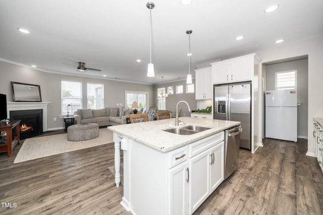 512 Courtship Cv, Durham, NC 27703 - kitchen with appliances with stainless steel finishes, a warm lit fireplace, dark wood-style flooring, a kitchen island with sink, and recessed lighting
