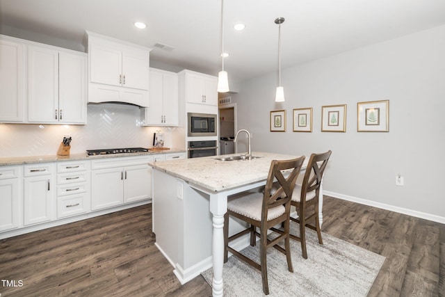 512 Courtship Cv, Durham, NC 27703 - kitchen with stainless steel appliances, a kitchen breakfast bar, dark wood-style floors, white cabinetry, and recessed lighting