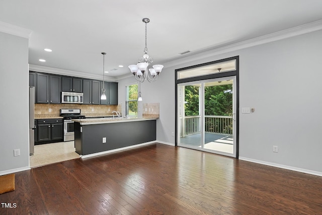 409 Kilcornac Ct, Fuquay Varina, NC 27526 - kitchen with stainless steel appliances, crown molding, a peninsula, a chandelier, and tasteful backsplash