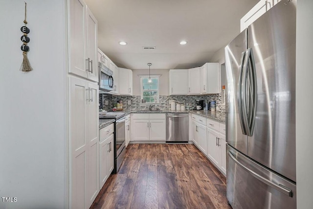 784 Crawford Rd, Coats, NC 27521 - kitchen with appliances with stainless steel finishes, light stone countertops, a sink, dark wood-type flooring, and backsplash