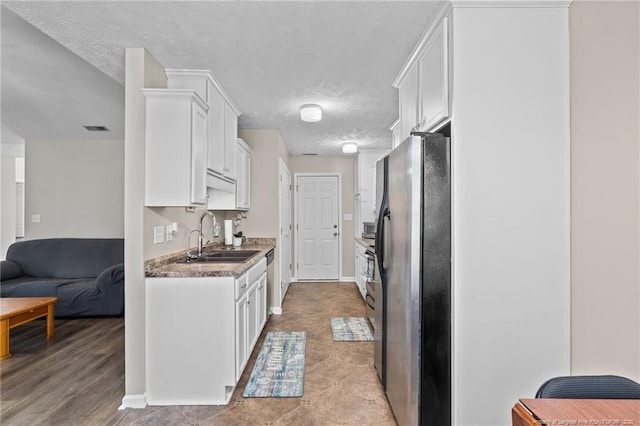 306 Longleaf Pines Dr, Raeford, NC 28376 - kitchen featuring appliances with stainless steel finishes, a sink, white cabinets, and a textured ceiling