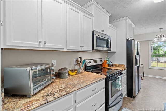 306 Longleaf Pines Dr, Raeford, NC 28376 - kitchen with stainless steel appliances, white cabinetry, a textured ceiling, light stone countertops, and hanging light fixtures