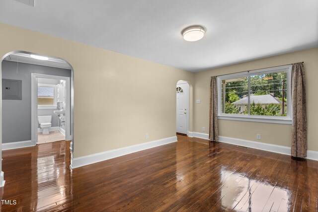2712 Broad St, Durham, NC 27704 - empty room featuring arched walkways, wood-type flooring, electric panel, and baseboards
