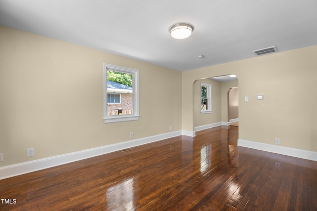 2712 Broad St, Durham, NC 27704 - unfurnished room featuring arched walkways, hardwood / wood-style floors, and baseboards