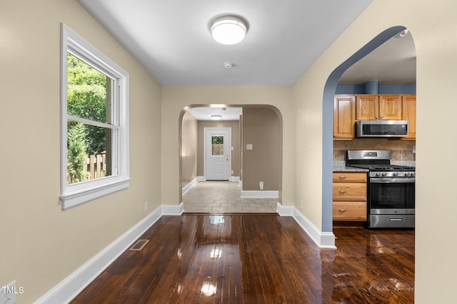 2712 Broad St, Durham, NC 27704 - foyer entrance featuring arched walkways, baseboards, and dark wood-style flooring