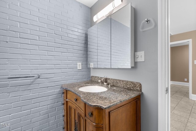 2712 Broad St, Durham, NC 27704 - bathroom with vanity, brick wall, tile patterned flooring, and baseboards