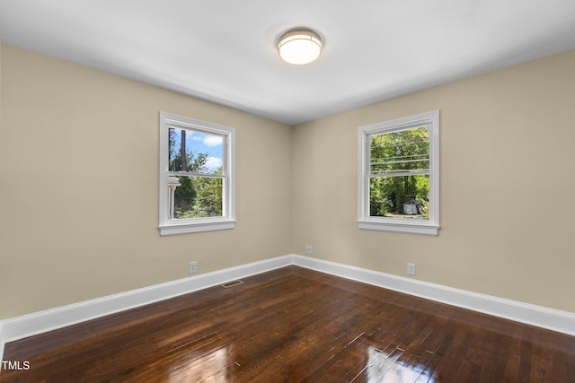 2712 Broad St, Durham, NC 27704 - unfurnished room featuring baseboards, healthy amount of natural light, and dark wood-style floors