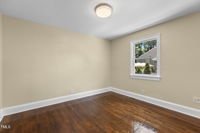 2712 Broad St, Durham, NC 27704 - spare room with baseboards and dark wood-type flooring