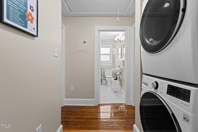 2710 Broad St, Durham, NC 27704 - laundry area with attic access, stacked washer / dryer, wood finished floors, and baseboards