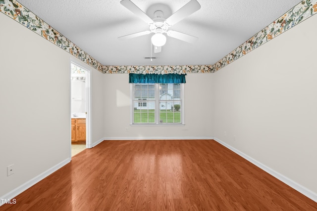 3027 Maple Unit T1, Burlington, NC 27215 - spare room with wood finished floors, plenty of natural light, a ceiling fan, and a textured ceiling