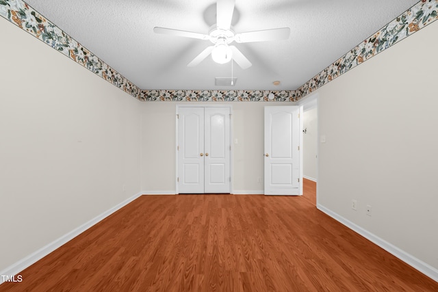 3027 Maple Unit T1, Burlington, NC 27215 - unfurnished bedroom featuring wood finished floors, a textured ceiling, baseboards, a ceiling fan, and a closet