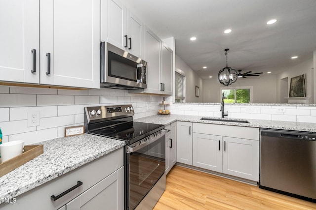 2001 Turtle Point Dr, Raleigh, NC 27604 - kitchen with stainless steel appliances, light wood-style floors, tasteful backsplash, a chandelier, and recessed lighting