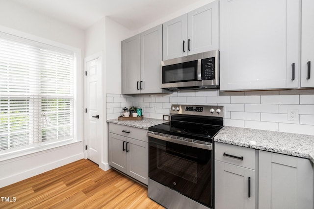 2001 Turtle Point Dr, Raleigh, NC 27604 - kitchen with stainless steel appliances, light wood-type flooring, gray cabinets, and tasteful backsplash
