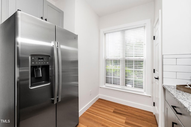 2001 Turtle Point Dr, Raleigh, NC 27604 - kitchen featuring stainless steel refrigerator with ice dispenser, light wood finished floors, and light stone counters