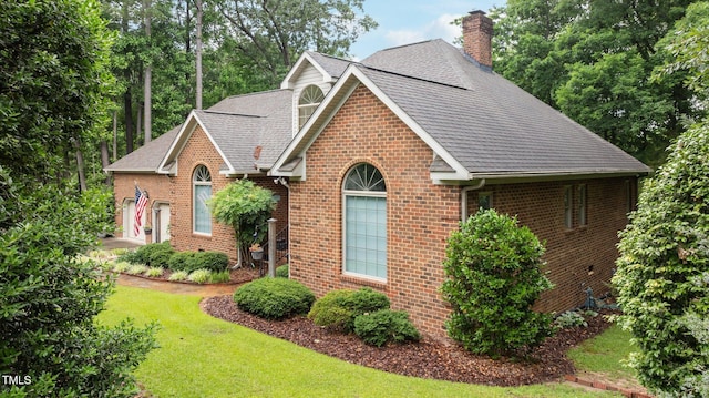 414 Bakewell Ct, Wake Forest, NC 27587 - view of front of house with a chimney, brick siding, a shingled roof, and a front lawn