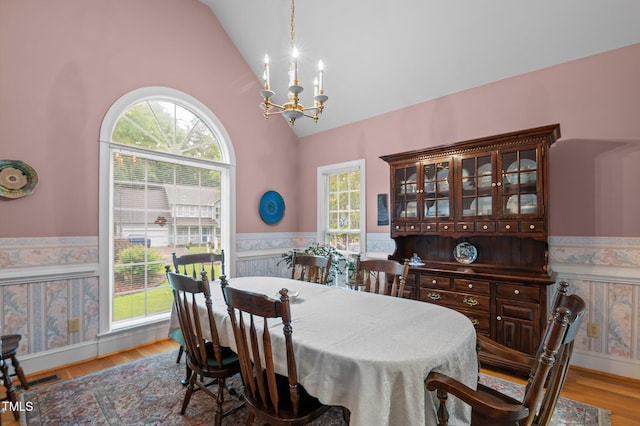 414 Bakewell Ct, Wake Forest, NC 27587 - dining space featuring wainscoting, a chandelier, light wood-style flooring, and high vaulted ceiling
