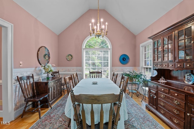 414 Bakewell Ct, Wake Forest, NC 27587 - dining space with a chandelier, a wainscoted wall, vaulted ceiling, and light wood-style flooring