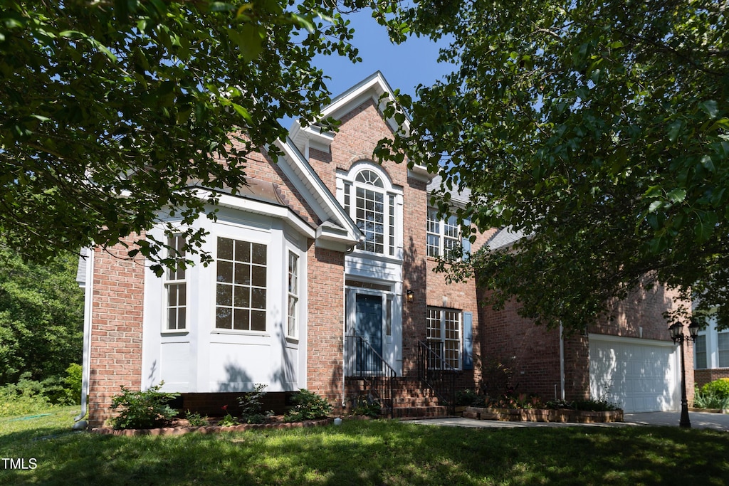 227 Shalimar Dr, Durham, NC 27713 - traditional-style house with brick siding, a front lawn, and a garage