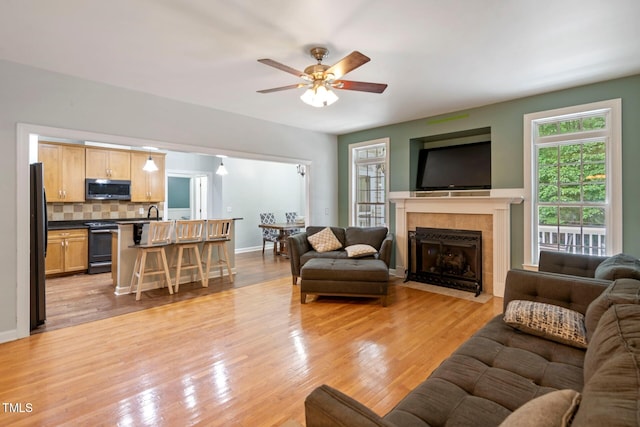 395 Timberlands Dr, Louisburg, NC 27549 - living area featuring a ceiling fan, a tiled fireplace, and light wood finished floors