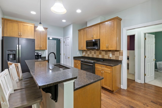 395 Timberlands Dr, Louisburg, NC 27549 - kitchen with stainless steel appliances, a sink, dark wood-style flooring, a breakfast bar, and backsplash