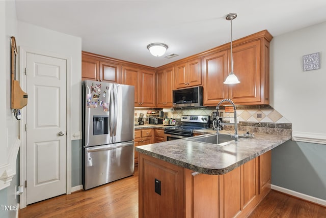 153 Hickory Nut Dr, Smithfield, NC 27577 - kitchen with appliances with stainless steel finishes, a peninsula, a sink, and brown cabinetry