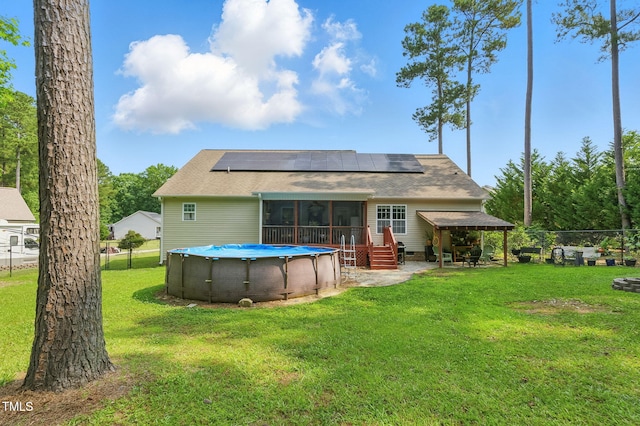153 Hickory Nut Dr, Smithfield, NC 27577 - back of property with a sunroom, solar panels, a patio area, and a shingled roof