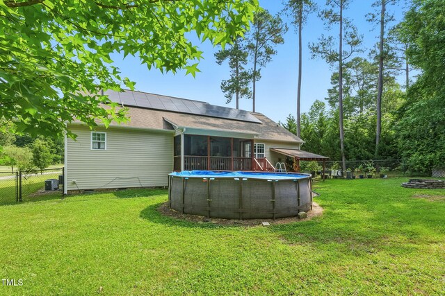 153 Hickory Nut Dr, Smithfield, NC 27577 - back of house featuring a sunroom, crawl space, solar panels, central air condition unit, and roof with shingles