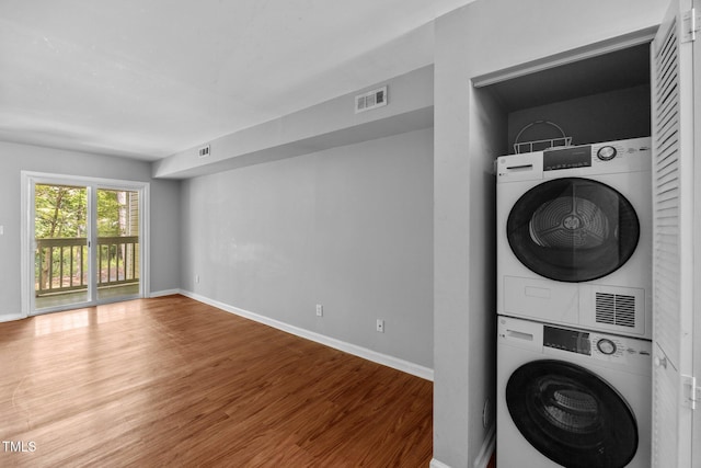 134 Kingsbury Dr, Chapel Hill, NC 27514 - laundry room with stacked washer and clothes dryer, wood finished floors, and baseboards