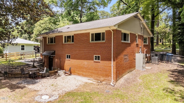 2005 Cole Mill Rd, Durham, NC 27712 - back of property featuring brick siding, a fenced backyard, a shingled roof, and cooling unit