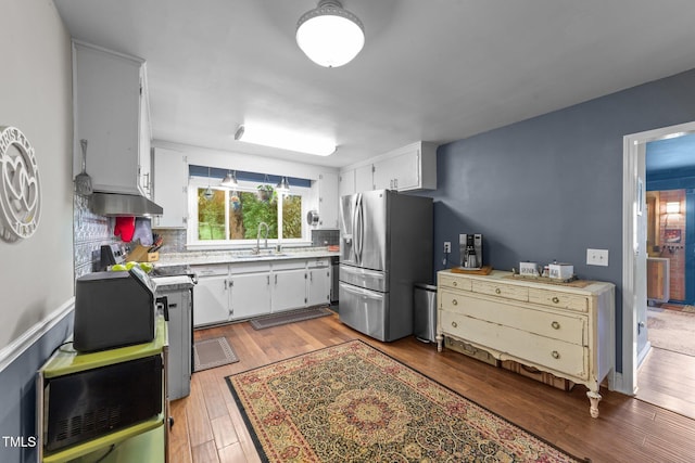2005 Cole Mill Rd, Durham, NC 27712 - kitchen featuring stainless steel fridge, a sink, light wood-style floors, tasteful backsplash, and light countertops