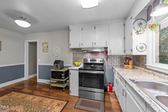 2005 Cole Mill Rd, Durham, NC 27712 - kitchen with stainless steel electric range oven, under cabinet range hood, light countertops, a sink, and backsplash
