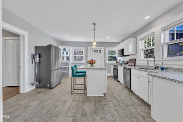 602 Dunbar St, Durham, NC 27701 - kitchen featuring appliances with stainless steel finishes, a sink, a center island, white cabinets, and recessed lighting