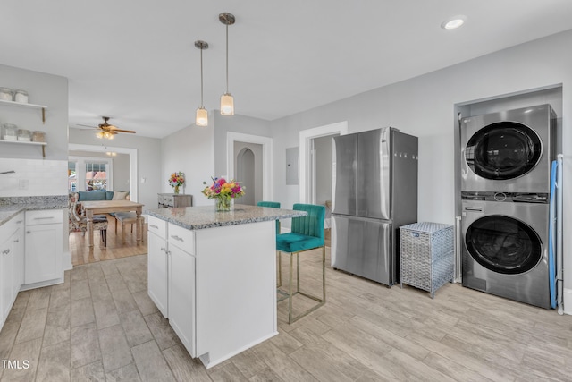 602 Dunbar St, Durham, NC 27701 - kitchen featuring freestanding refrigerator, stacked washer and clothes dryer, open shelves, white cabinets, and light stone counters